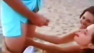 2 girls suck a guy's cock at the beach