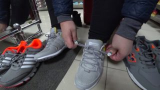 Foot fetish in a public shoe store. Fat legs try on sneakers.