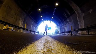 Playful petite babe gives a nice blowjob in the tunnel