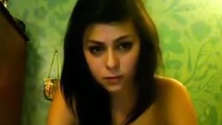 Cute brunette girl plays with her tits and pussy on her bed