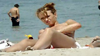 Pretty blonde skank on the beach topless sunbathing