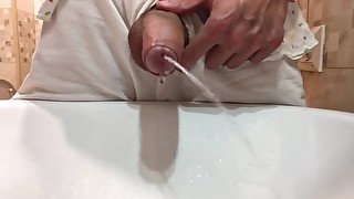 Gay stud twink pissing in a sink with a hard uncut dick