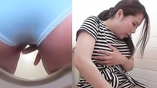 An exquisite brunette in a striped blouse in a steamy session with her own vagina in a public WC