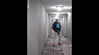athlete in tights takes his cock out in hotel hall