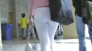 Fit brunette in white skintight pants walks in a student hall candid porn