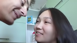 An Asian teen gets her shaved pussy fucked in a kitchen