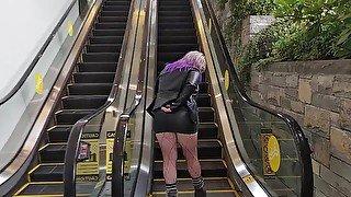 Milf in mini skirt rubs pussy on public escalator