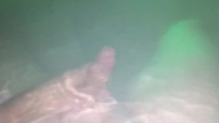 Underwater jerk off session in backyard in steamy hot tub glowing at night.