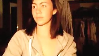 Cute brunette girl fingers her shaved pussy and rubs her clitoris, while watching internet porno.