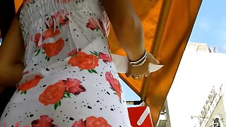An inquiring camera looks under a white dress with rose print