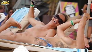 Tattooed girl and her topless friend tanning topless