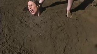 Outdoor BDSM with a sand bondage on the beach