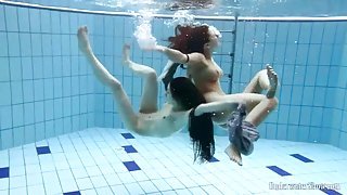Two skinny chicks swimming naked underwater