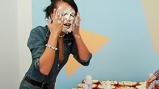 Ladies throw pies on each others faces and make a mess