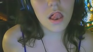 Brunette chick licks her lips in front of a webcam