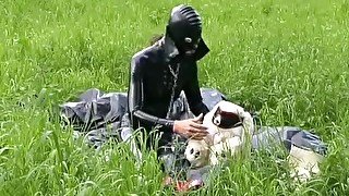 Rubber girl full in black latex catsuit and mask plays with herself outdoor in a meadow - Part 1