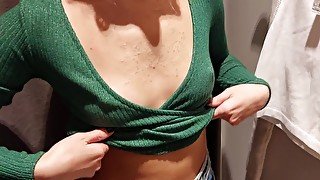 A student in the fitting room measures the tops on her small tits
