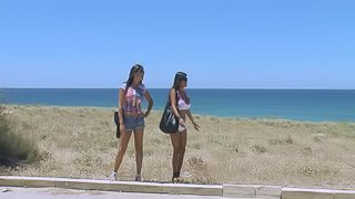 Three sexy chicks in bikinis go lesbian at a beach