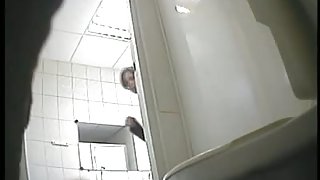 A juicy brunette caught by a spy camera pissing in a public toilet