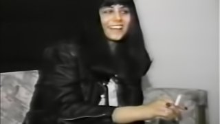 Dressed in all black, she smiles and smokes a ciggarette during this interview