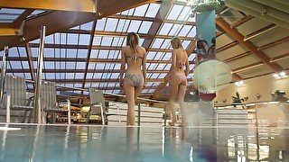 Two white young sexy girls dive in the pool and undress on cam