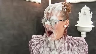 In a gloryhole this glasses wearing babe fucks a dildo