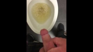 POV pissing into a toilet in a public bathroom and jerking off and cumming