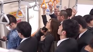 A very daring Japanese babe sucks a guy's cock on a crowded subway