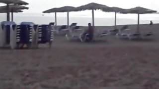 Milf sucks and jerks her man's cock at a beach on vacation